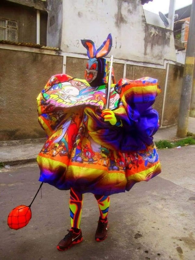 Mas os Clóvis/Bate-bolas vão muito além de uma simples roupa colorida e uma máscara um tanto quanto assustadora.  Reprodução: Flipar