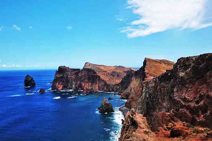 O Miradouro Ponta do Rosto oferece uma vista impressionante da costa nordeste da Madeira, com falésias dramáticas e o oceano azul profundo. Este é um excelente local para fotos panorâmicas, capturando a beleza natural da ilha. Reprodução: Flipar