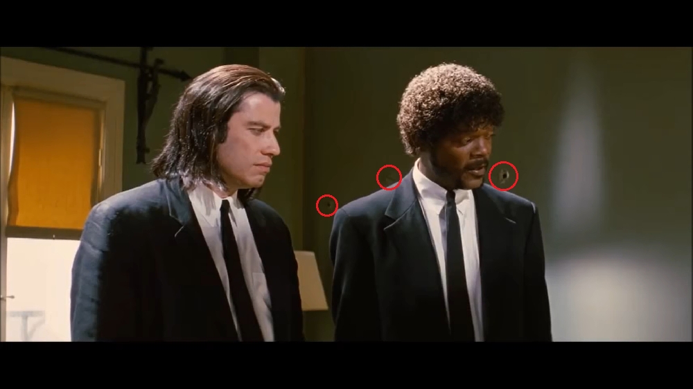 Marcas de bala em “Pulp Fiction” (1994): Antes mesmo de tentarem balear Jules (Samuel L. Jackson) e Vincent (John Travolta), as marcas de bala já apareciam na parede atrás dos dois. Reprodução: Flipar