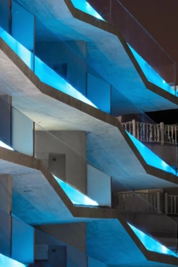 O empreendimento é da VIW Residence e causa mesmo uma curiosidade pela ideia inovadora e pelo efeito visual conquistado, pois a piscina fica visível diante da proteção de vidro que, com a iluminação, ganha um.tom de azul vibrante.. Reprodução: Flipar