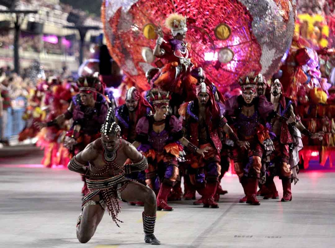 A Comissão de Frente é julgada de acordo com a concepção e a capacidade de causar impacto em sua função de saudar o público e apresentar a escola na avenida. Ao longo da história do Carnaval, foi o quesito que mais evoluiu, passando de uma apresentação simples da Velha Guarda para truques de mágica e o uso de tripés. Reprodução: Flipar