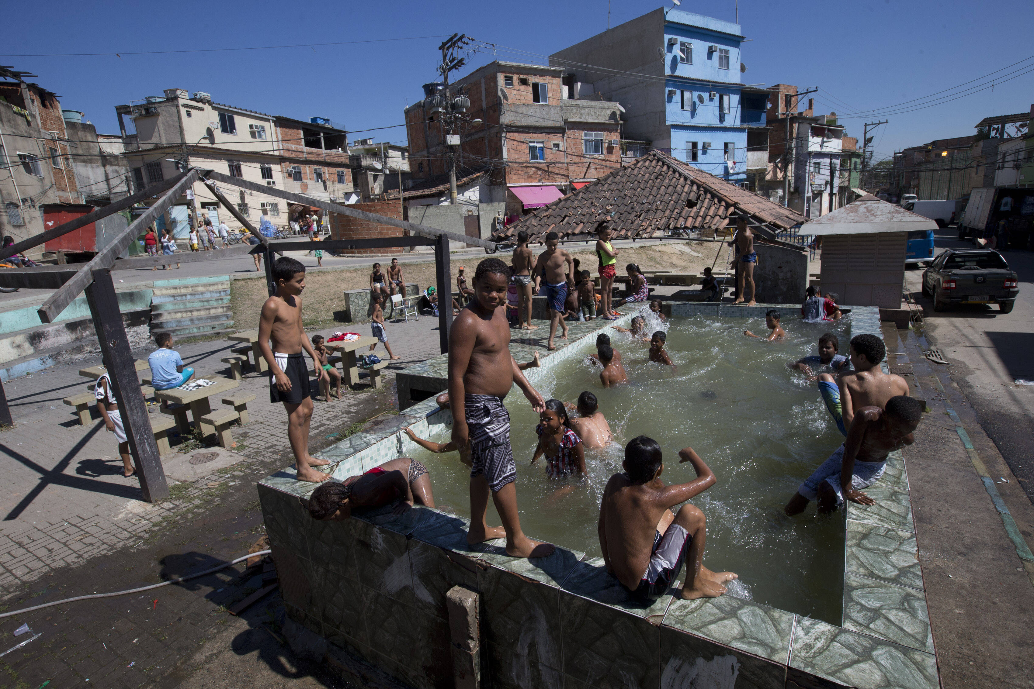 Piscina sem água tratada é usada por crianças para aliviar o calor. Foto: Silvia Izquierdo/AP
