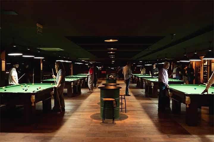 Os locais onde mais se joga sinuca incluem o Reino Unido, onde o snooker é extremamente prestigiado, além de EUA, China, Austrália e Brasil. Bares, clubes e salões de bilhar são os espaços mais comuns, mas também há academias especializadas no esporte. Reprodução: Flipar