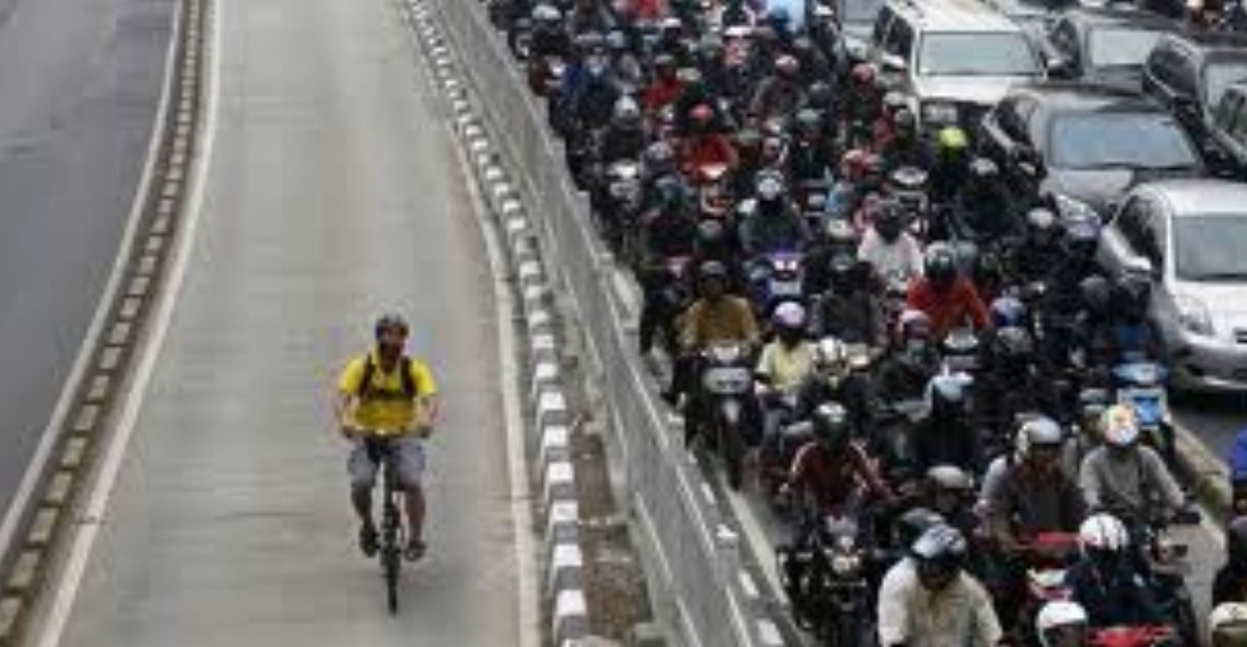 A melhor opção de transporte em Jacarta é a bicicleta, à margem do emaranhado de motos e carros. O trânsito é tão ruim que,  nos horários de pico, é proibido passar com carro que tenha menos de 3 pessoas. Um incentivo à carona.  Reprodução: Flipar