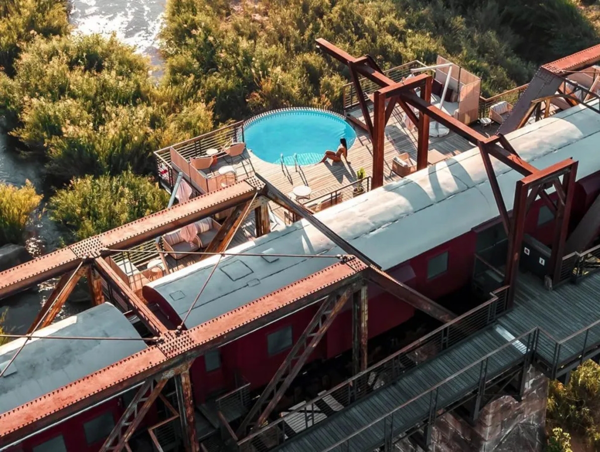 Composto por 5 vagões sobre uma ponte, o hotel Kruger Shalati oferece 24 suítes modernas, com varandas e piscina.  Reprodução: Flipar