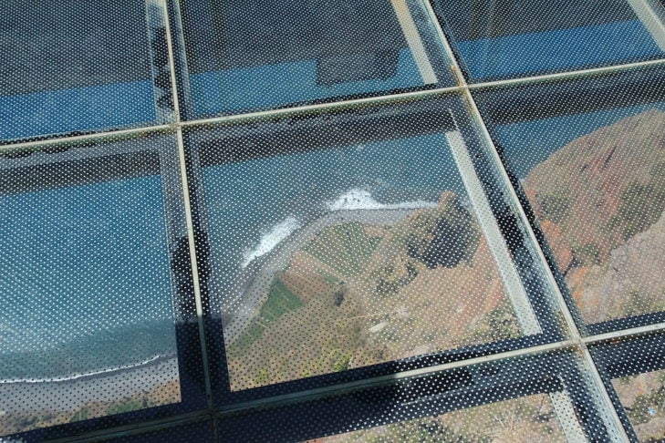 No topo da falésia, há um mirante com piso de vidro que oferece uma vista incrível para o mar e a cidade de Funchal.  Reprodução: Flipar