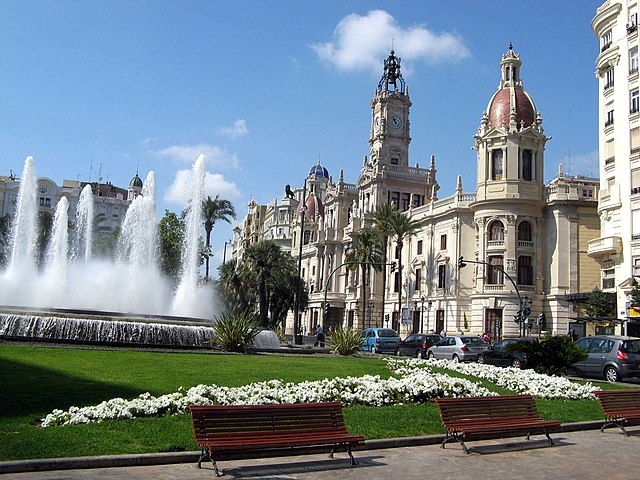 Em Valencia, a Plaza_del_Ayuntamiento (Praça da Câmara Municipal) tem edifícios em estilo eclético erguidos na primeira metade do século 20, inclusive a Câmara Legislativa da cidade. E ali destacam-se ainda uma fonte circular e esculturas.  Reprodução: Flipar