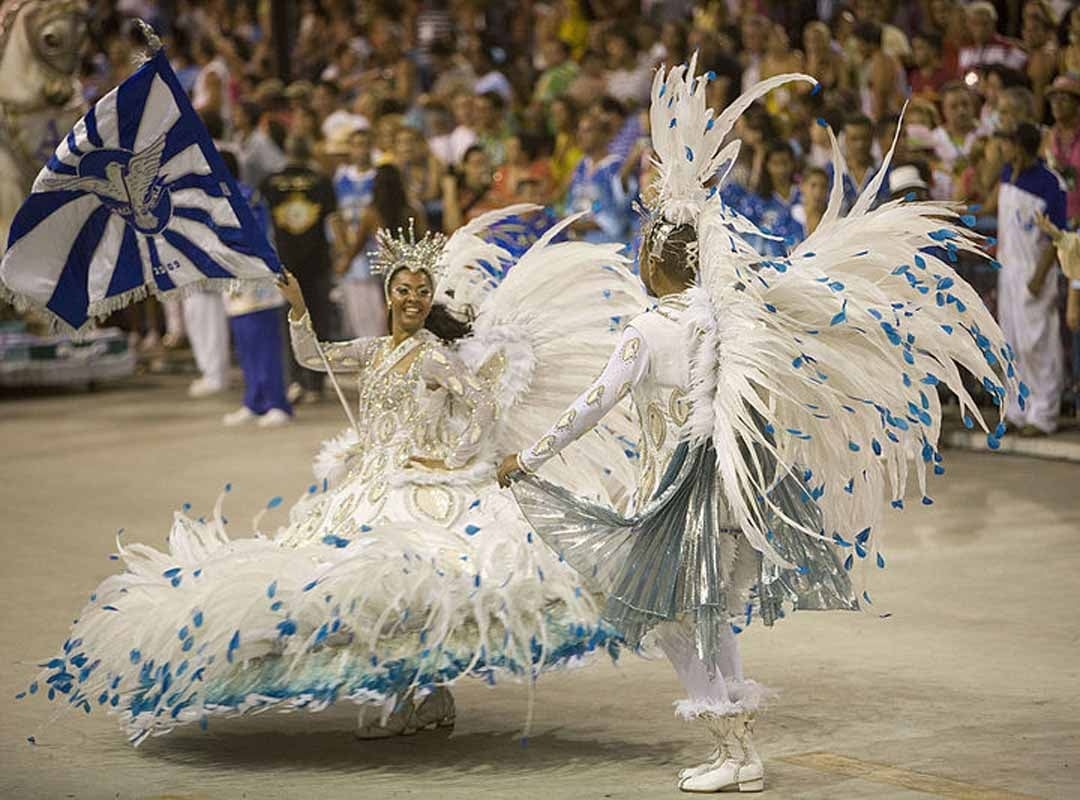 Anteriormente, era comum a referência à vestimenta da corte do século XIX, mas, hoje em dia, o enredo da escola passou a influenciar a construção do que se veste. Dessa forma, a fantasia do casal ganhou novas possibilidades de adereços, formatos e recursos materiais.  Reprodução: Flipar