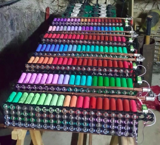 Para otimizar o desempenho e lidar com desafios como a descarga irregular, o criador passou a desmontar as baterias e utilizar suas células individualmente, montando racks personalizados. Reprodução: Flipar
