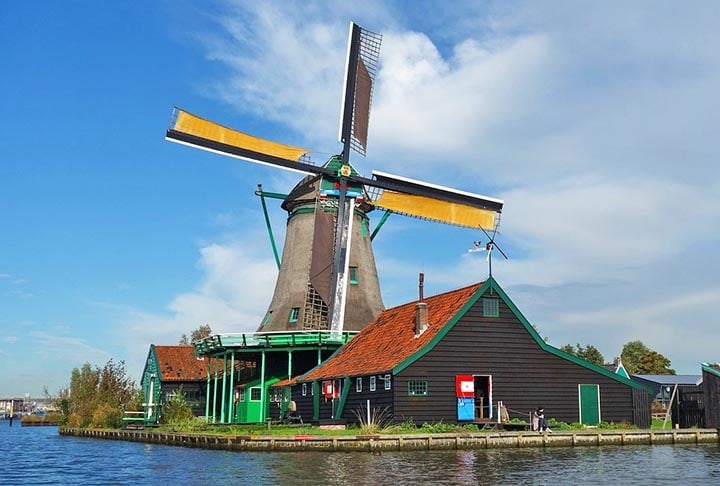 A cidade de Zaandam, a 22 km de distância da capital Amsterdam, abriga no bairro de Zaanse Schans um dos principais pontos turísticos do país. São seis moinhos, casas verdes e marrons, um museu que narra a história da região, além de lojas produtoras de itens típicos como queijos e tamancos de madeira.  Reprodução: Flipar