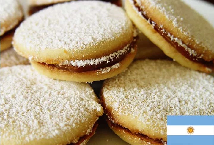 3º) Alfajores (Argentina): Consiste em duas ou mais camadas de biscoito macio (geralmente feito com farinha de trigo, amido de milho e açúcar) unidas por recheios como doce de leite, chocolate, ou geleia. Reprodução: Flipar