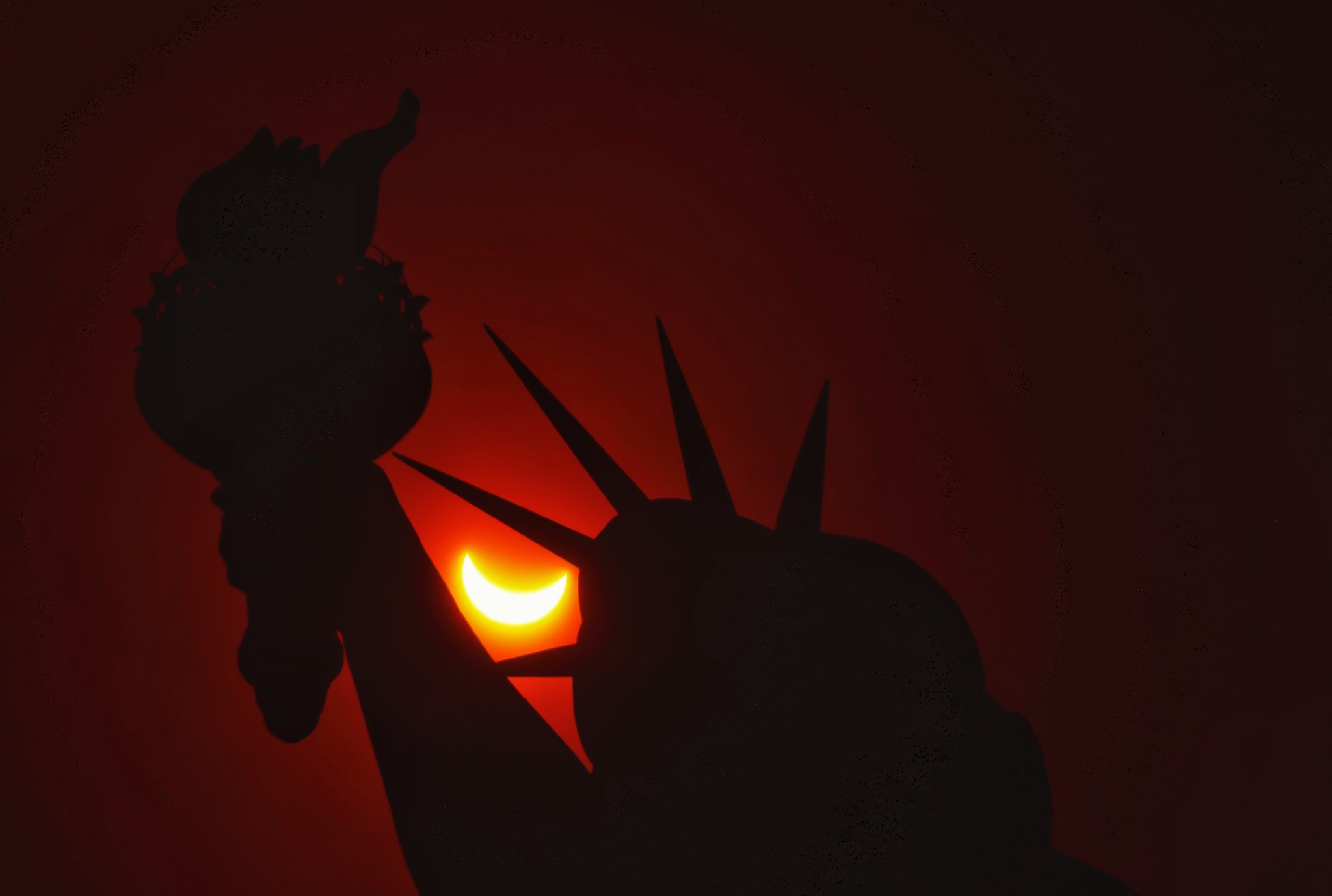 Estátua da Liberdade, em Nova Iorque, com o eclipse solar total ocorrendo ao fundo Reprodução/Gary Hershorn/ Reuters