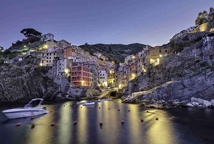 Conhecida por suas casas coloridas empilhadas nas encostas rochosas, a vila oferece vistas deslumbrantes do Mar da Ligúria. É famoso por ser um ótimo lugar para apreciar o pôr do sol.  Reprodução: Flipar