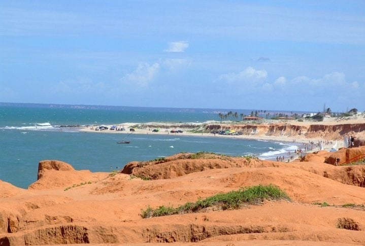 Desde as décadas de 60 e 70, as falésias de Canoa Quebrada atraem visitantes devido à sua paisagem deslumbrante e ao contraste vibrante entre o azul do oceano e as formações rochosas coloridas. Reprodução: Flipar