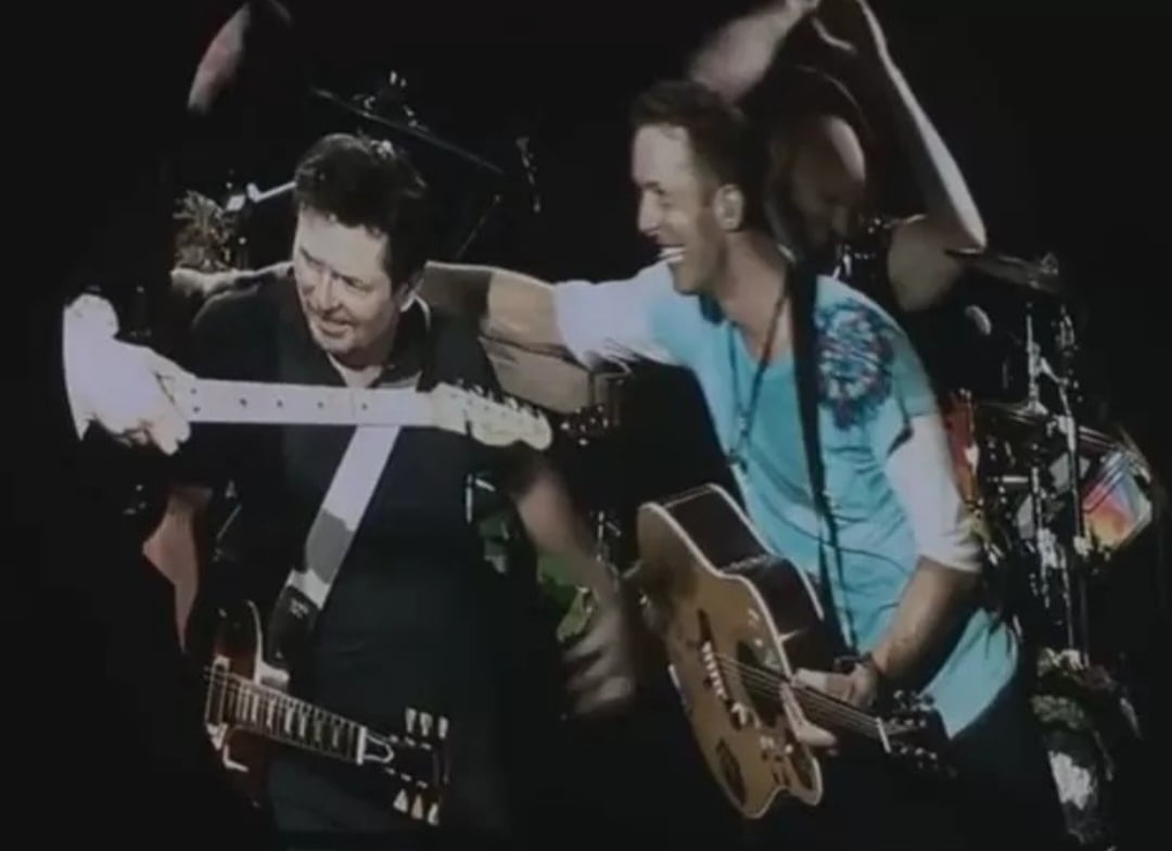 Michael J.Fox já havia tocado com Coldplay em 2016, durante uma apresentação em Nova York. O vocalista da banda, Chris Martin, diz que a saga De Volta para o Futuro, grande sucesso de J.Fox, é que o inspirou a montar o grupo musical. Reprodução: Flipar