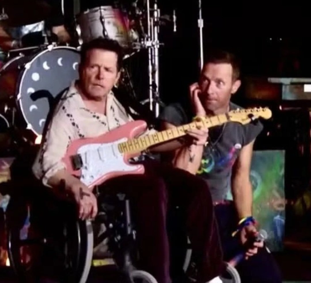 O ator canadense Michael J.Fox surpreendeu o público ao entrar no palco para tocar guitarra durante o show da banda Coldplay. Reprodução: Flipar