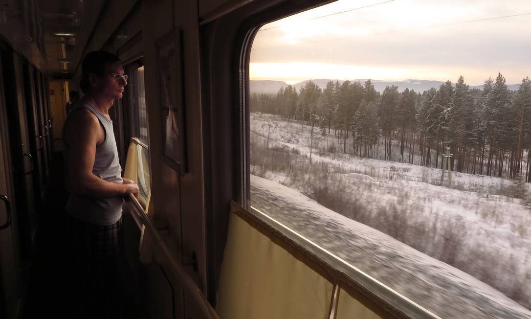 Passageiro observa a paisagem no trem da Transiberiana: viagem é imersão na paisagem e cultura russas. Foto: Juarez Becoza / Juarez Becoza