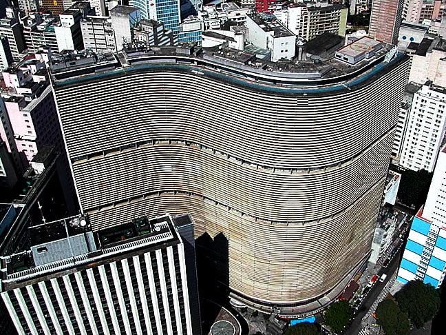 Edifício Copan - Com linhas sinuosas, é um dos símbolos da moderna arquitetura brasileira. O prédio, em São Paulo, tem a maior estrutura de concreto armado do país: 115m de altura, 32 andares e 120 mil m2 de área construída. Inaugurado em 1966, tem lojas e residências.  Reprodução: Flipar