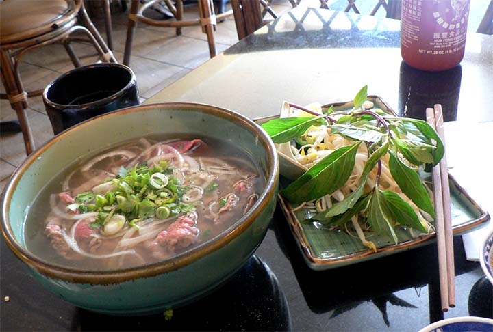 Pho: este prato representativo da gastronomia vietnamita trata-se de uma espécie de caldo claro, porém de sabor intenso, feito com ossos de boi, rabo de boi, carne, cebola e especiarias. É servido com macarrão de arroz e fatias finas de carne bovina crua, cebola roxa e folhas de louro. Reprodução: Flipar