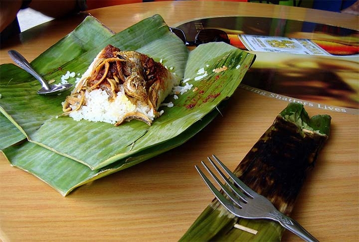 Nasi Lemak: prato nacional da Malásia, o nasi é um arroz embalado em uma folha de bananeira e consumido como café da manhã. Os acompanhamentos podem ser frango, pepino, anchovas, amendoim e ovo.  Reprodução: Flipar