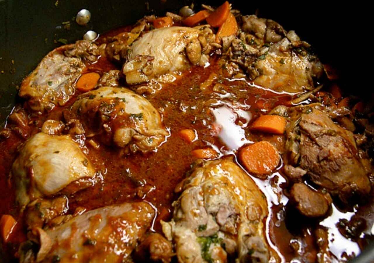 Coq au Vin - Um ensopado de frango cozido em vinho tinto, geralmente acompanhado de cogumelos, cebolas e bacon Reprodução: Flipar