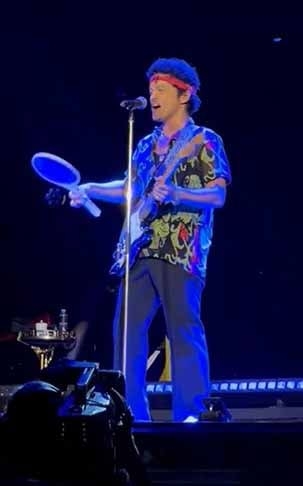 O cantor Bruno Mars protagonizou uma cena curiosa ao subir no palco do estádio Mané Garrincha, em Brasília, no dia 27/10, munido de uma raquete elétrica para matar mosquitos.  
 Reprodução: Flipar