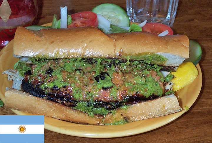 7º - Choripan - Um dos principais pratos da Argentina, bastante procurado por estrangeiros. É um lanche basicamente constituído por duas fatias de pão e chorizo, uma espécie de linguiça, com chimichurri ou outro molho.  Pode ser servido com churrasco ou como uma refeição rápida.  Reprodução: Flipar