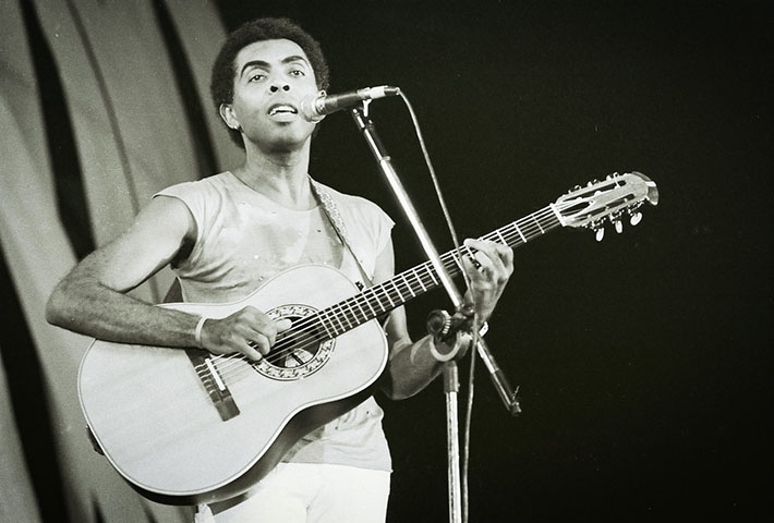 A postura política do tropicalismo levou à repressão em meio a ditadura militar: Gilberto Gil foi preso em dezembro de 1968 e, após breve detenção, se exilou em Londres, onde permaneceu até o retorno ao Brasil em 1972.. Foto: Reprodução: Flipar