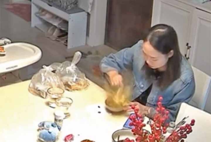 No vídeo, a moça se prepara para comer sua refeição e tenta cortar o ovo cozido que está dentro de uma sopa quente.