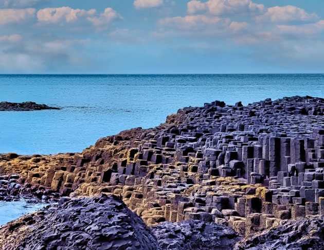 Calçada dos Gigantes (Reino Unido) - Reúne cerca de 40 mil colunas poligonais de basalto, formadas pelo resfriamento da lava de um vulcão há 60 milhões de anos. Os trechos têm diferentes alturas, formando degraus, em alguns momentos desordenados, e em outros mais lineares. Os topos têm formato de favo de mel. 