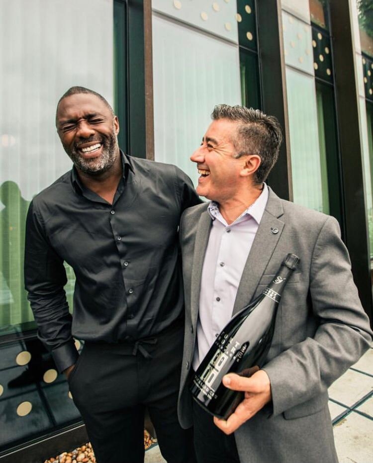 Idris Elba - Ganhador de 5 prêmios Emmy Awards, o ator britânico entrou para o ramo de vinhos durante a pandemia, em 2020, ao criar sua própria marca, a “Porte Noire”. Elba inaugurou até um bar em Londres para quem quiser experimentar as bebidas! Reprodução: Flipar