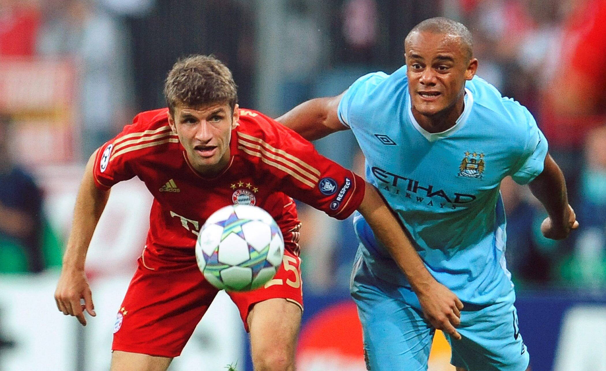 Thomas Müller e Kompany observam de perto a bola no duelo entre Bayern e City EFE