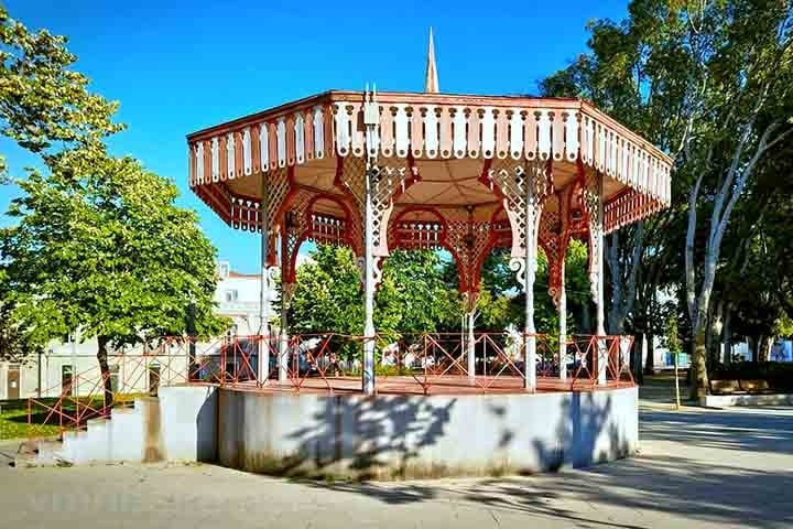 Normalmente construído em ferro fundido ou alvenaria, possui um pequeno palco elevado. São frequentes em praças centrais e jardins públicos. Reprodução: Flipar