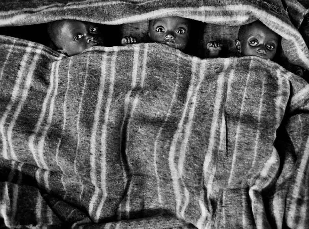 Salgado descreveu em livro a obra “Êxodus” como “uma história perturbadora, pois poucas pessoas abandonam a terra natal por vontade própria”. A câmera capta migrantes, refugiados e exilados tentando vencer a pobreza e as guerras. 
 Reprodução: Flipar