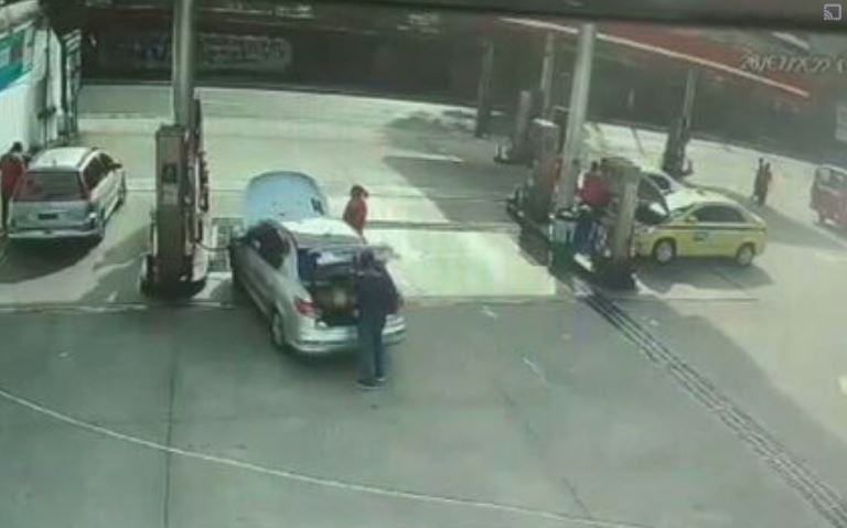 Uma câmera de monitoramento gravou tudo. O motorista Mario Magalhães, de 67 anos, vai até a traseira do carro e abre o porta-malas, onde ficam armazenados os cilindros de gás.  Reprodução: Flipar