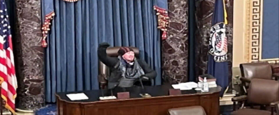 Manifestante senta em uma das cadeiras do Senado. Foto: Reprodução