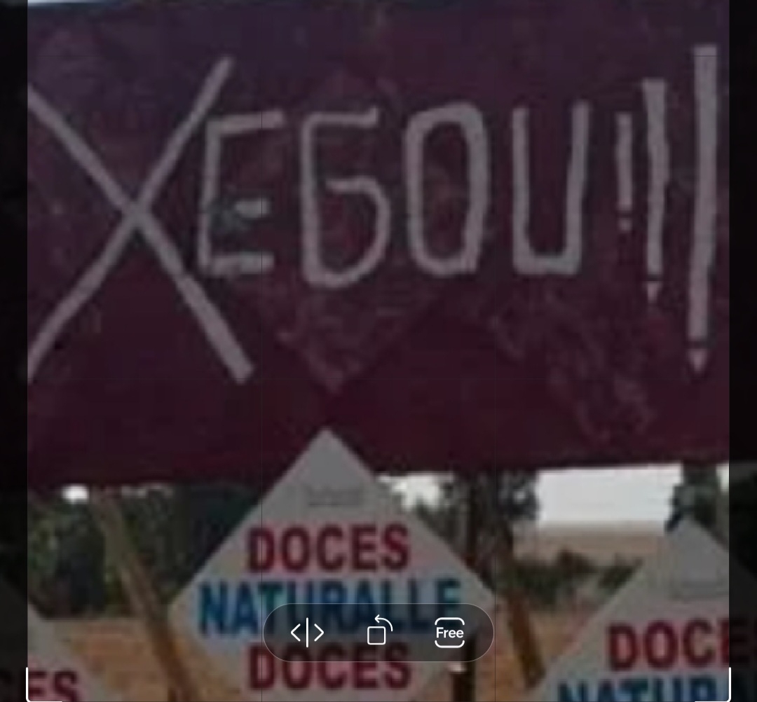 Quem passa imagina se o erro - por ser tão grotesco - aeria proposital e com qual objetivo. O fato é que abaixo da placa surge o nome de jma empresa: Naturelle Doces. Tudo leva a crer que seja uma jogada de marketing para atrair os viajantes. 