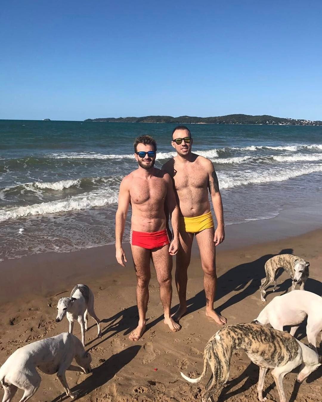 Rafael e seu companheiro na praia com as cadelas de estimação