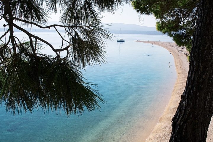 A praia da Zlatni Rat é considerada por muitos a mais bonita do país. Com águas claras e calmas onde famílias aproveitam o verão.   Reprodução: Flipar