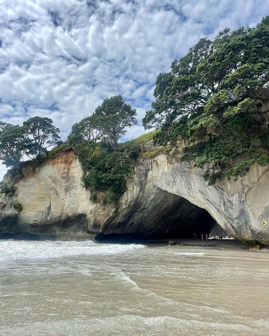 A passagem por rocha entre as duas faixas de areia da Cathedral Cove, praia na Nova Zelândia.. Foto: Reprodução/Instagram 26.01.2023
