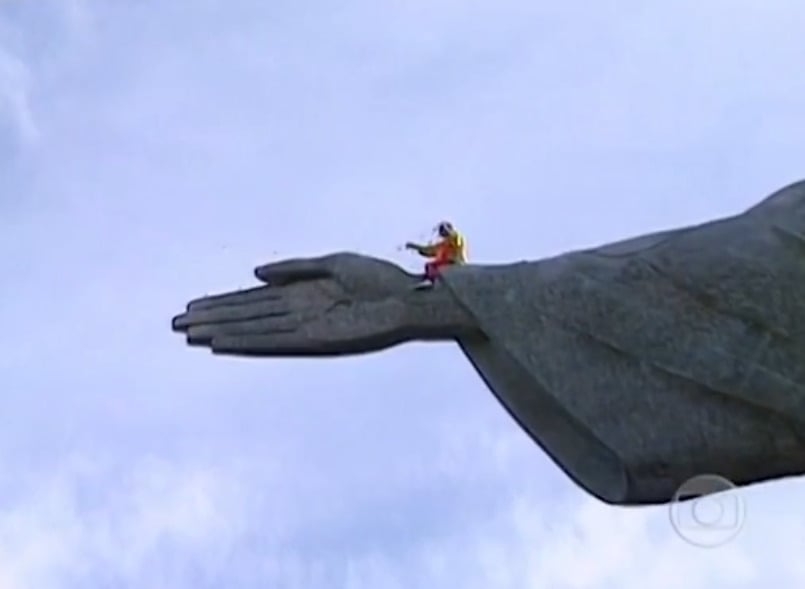 Equipado com itens de proteção, Renato se arrastou pelo braço do monumento. E lançou pétalas de flores lá do alto, numa celebração à cidade.  Reprodução: Flipar