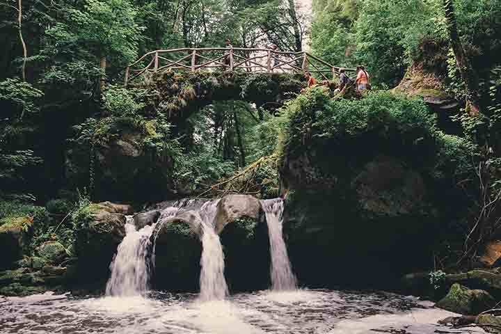Trilha de Müllerthal: Uma trilha de caminhada bem popular em Luxemburgo, que leva por paisagens deslumbrantes, cachoeiras, grutas e formações rochosas impressionantes. Um paraíso para os amantes da natureza. Reprodução: Flipar