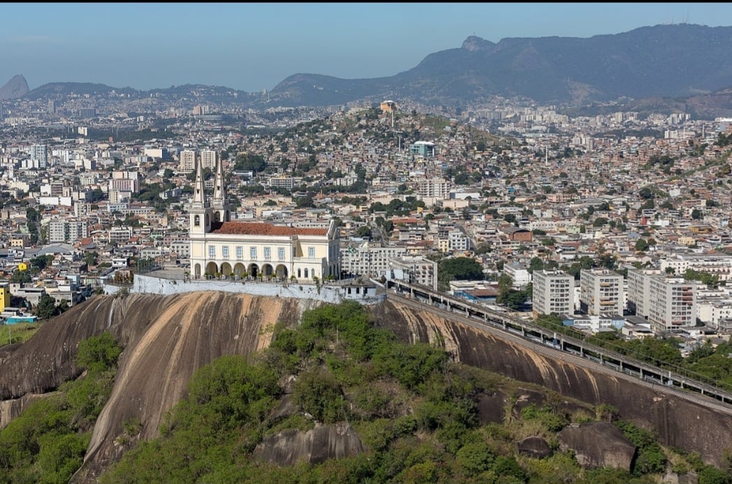 Escadaria da Igreja da Penha Rio de Janeiro (RJ)- A escadaria da Igreja da Penha é um marco religioso com 382 degraus, percorridos por peregrinos em devoção à Nossa Senhora da Penha. Localizada no bairro da Penha, oferece uma vista privilegiada da cidade e uma experiência espiritual única. A igreja, no topo do rochedo, simboliza fé, tradição e história carioca.
 Reprodução: Flipar