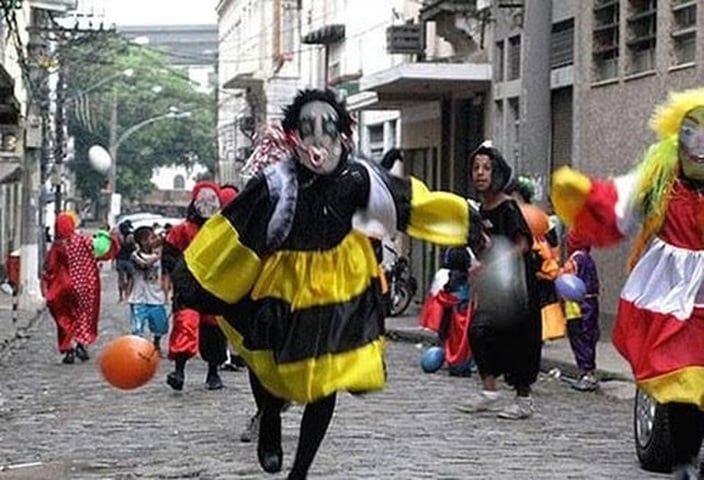 São os Clóvis ou Bate-bolas, que são, basicamente, uma fantasia colorida, uma máscara e uma bola de plástico. Reprodução: Flipar