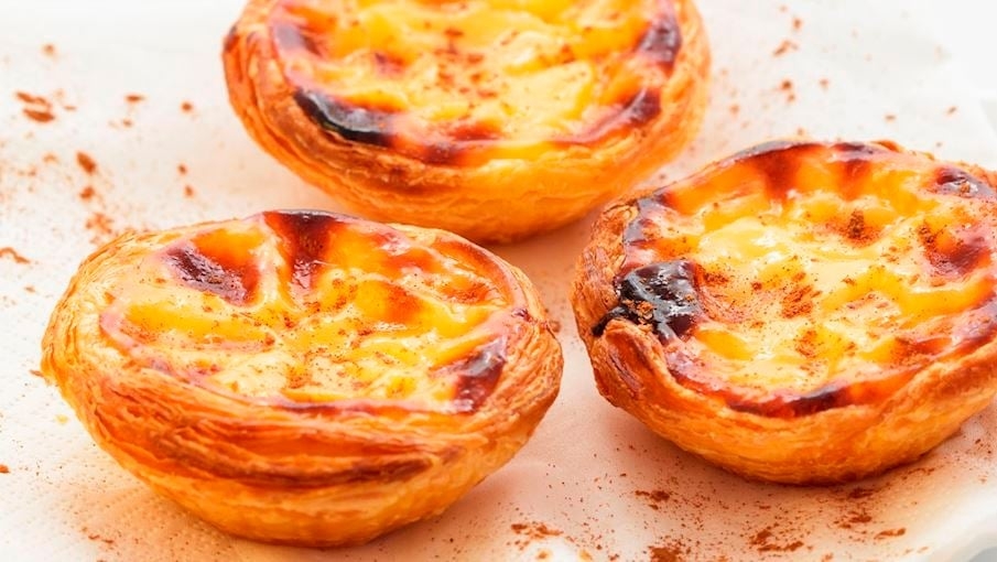 1º - Pastel de nata (Portugal): É um tradicional pastel de nata português popular em todo o mundo. Acredita-se que para melhor resultado o recheio não deve ser muito doce e não deve ter sabores de limão nem baunilha. Em vez disso, as tortas devem ser polvilhadas com canela e, de preferência, acompanhadas de uma xícara de café. Reprodução: Flipar