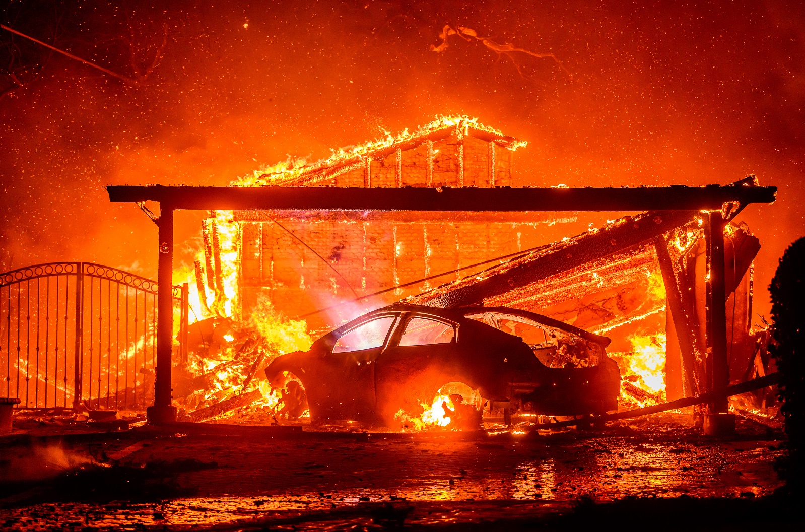 Um carro e uma casa queimam durante o incêndio de Eaton na área de Altadena, no Condado de Los Angeles, Califórnia, em 8 de janeiro de 2025 Josh Edelson/AFP