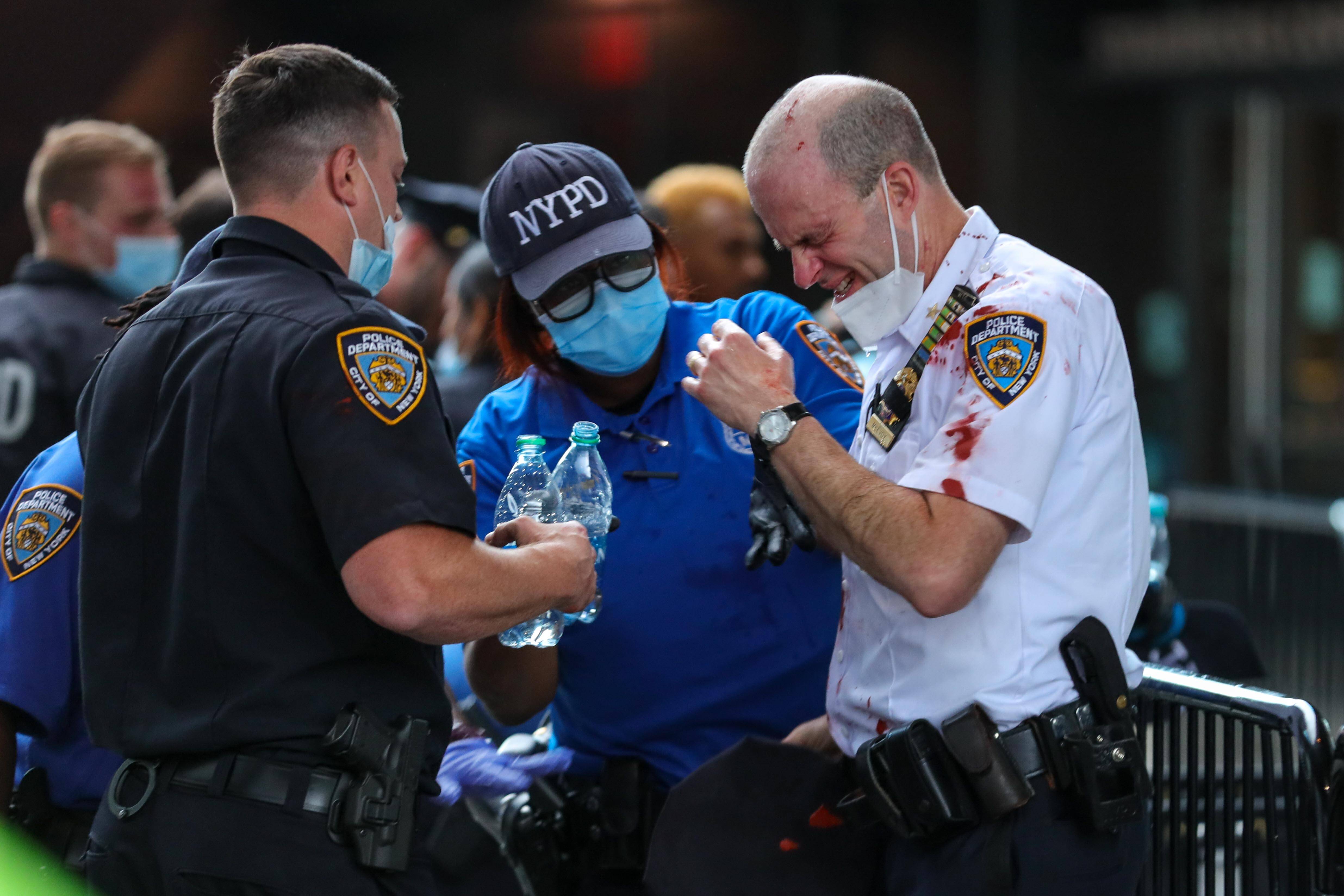Policial ferido durante manifestação em Nova York é atendido por paramédicos. Foto: William Volcov/Brazil Photo Press/Agencia O Globo