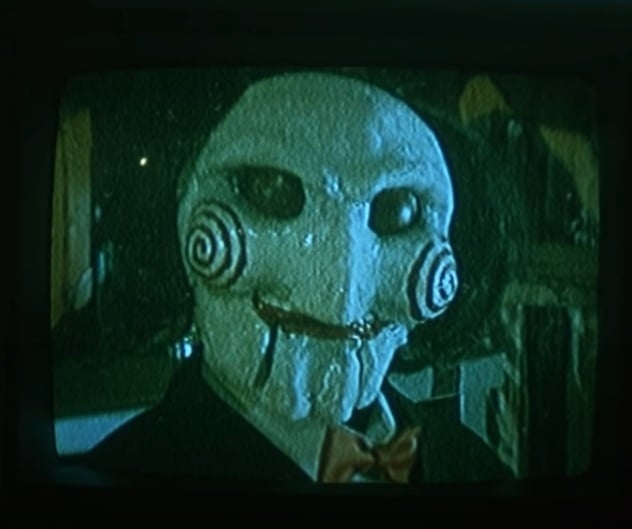 Jogos Mortais (2004): dirigido por James Wan, é um filme de terror psicológico onde pessoas encontram desafios aterrorizantes para sobreviver. Dispositivos de torturas e tomada de decisões extremas ditam o ritmo do enredo. O filme explora temas de moralidade, sobrevivência e justiça, com uma narrativa que se desenvolve em um ritmo tenso e intrigante, levando a uma conclusão impactante e surpreendente. Reprodução: Flipar