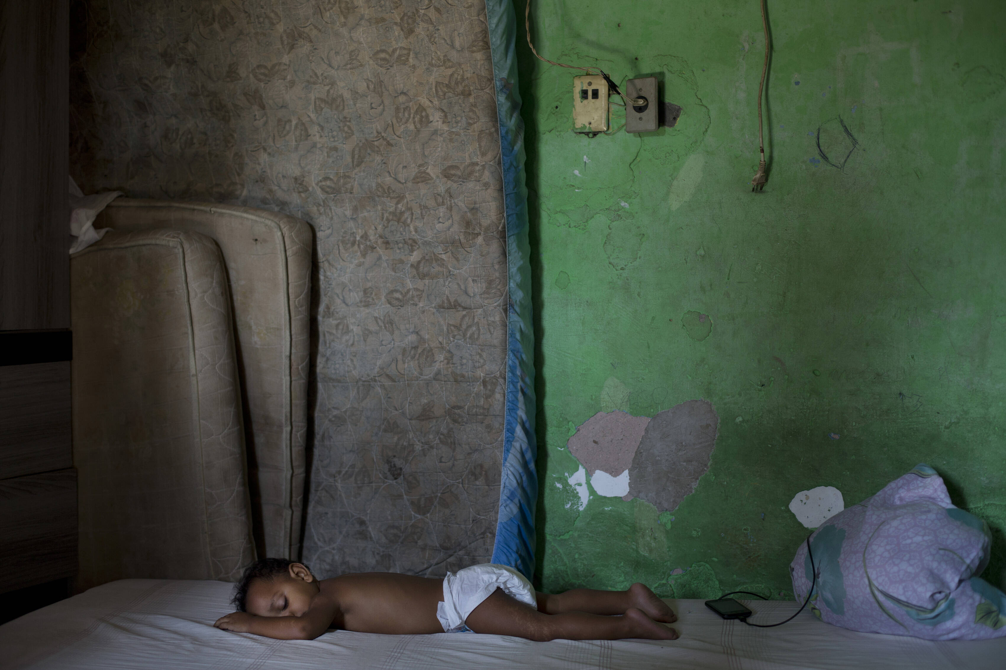Criança dorme em barraco na favela Mandela, uma das que sofrem com a falta de tratamento de esgoto na sede dos Jogos Olímpicos de 2016. Foto: Silvia Izquierdo/AP