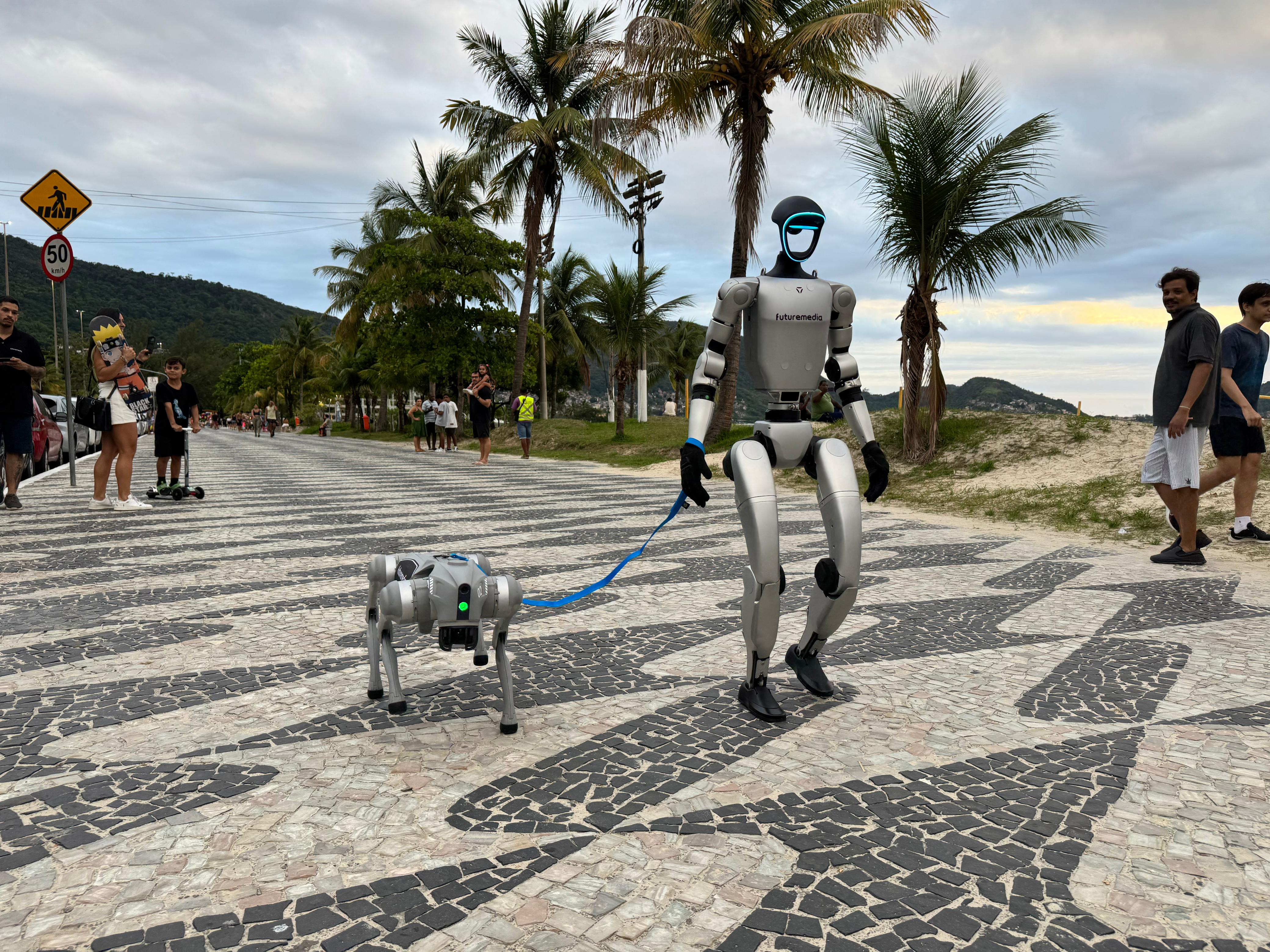 Robô humanoide passeando com o cachorro robótico na orla da praia do RJ Marcio Melo